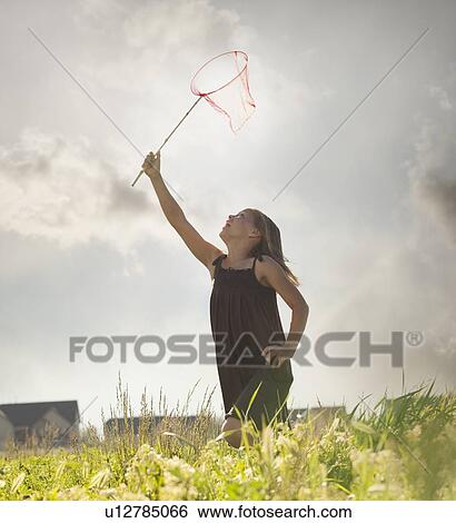 Stock Photograph - Young girl running with a butterfly net. Fotosearch