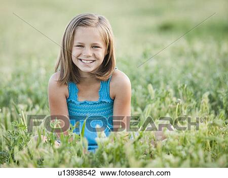 Young girl sitting in field View Large Photo Image Stock Image - Young girl sitting in field. Fotosearch