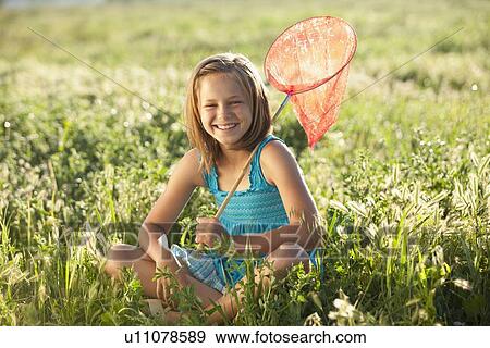 Young girl sitting in field with a butterfly net View Large Photo Image Stock Photo - Young girl sitting in field with a butterfly net. Fotosearch