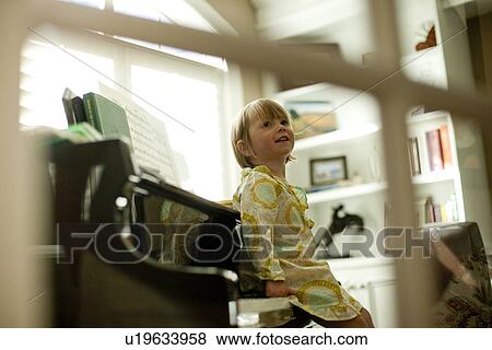 Young girl sitting on piano View Large Photo Image Stock Photo - Young girl sitting on piano. Fotosearch