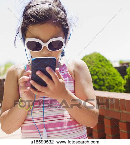 Stock Image - Young girl texting. Fotosearch