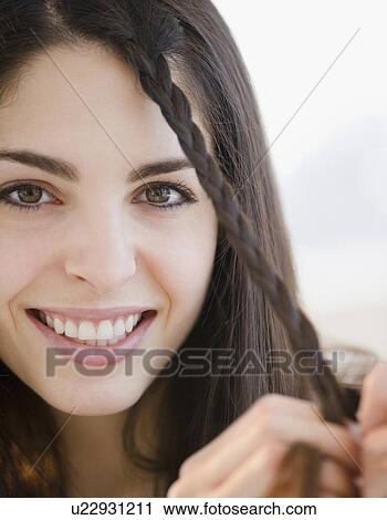 Young woman braiding her hair View Large Photo Image Stock Image - Young woman braiding her hair. Fotosearch