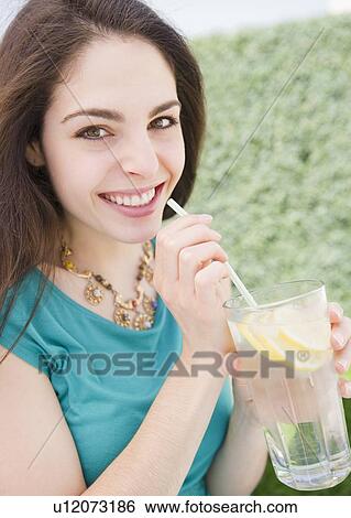 Young woman drinking lemon water View Large Photo Image Stock Photograph - Young woman drinking lemon water. Fotosearch