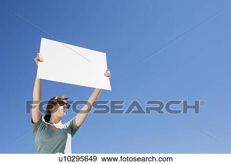 Stock Photo - Young woman holding a blank placard. Fotosearch