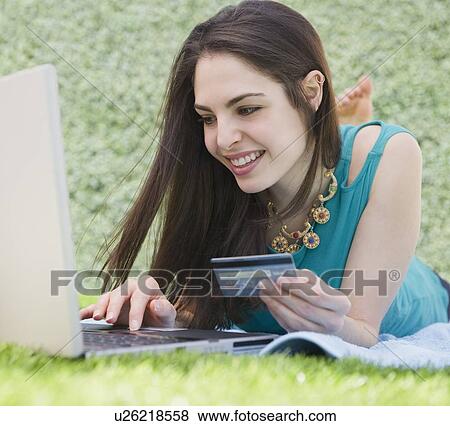Stock Photo - Young woman shopping online. Fotosearch