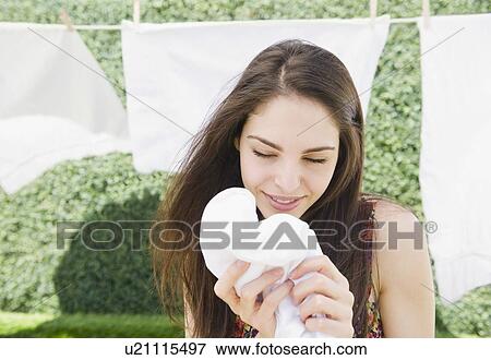 Young woman smelling clean laundry View Large Photo Image Stock Photo - Young woman smelling clean laundry. Fotosearch