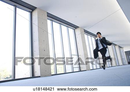 A businessman holding cellphone and running View Large Photo Image Stock Image - A businessman holding cellphone and running. Fotosearch