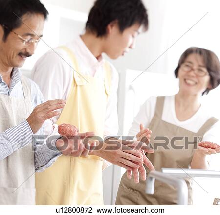 Stock Image - A family making hamburger stake. Fotosearch