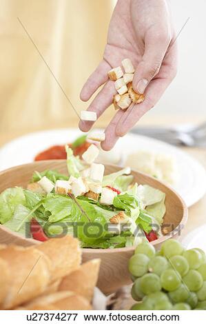 Stock Photo - A hand making salad. Fotosearch