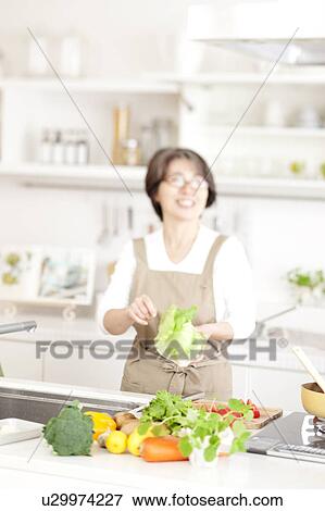 Stock Photo - A woman cooking. Fotosearch