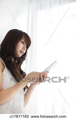 Stock Image - A woman looking at cellphone. Fotosearch