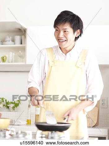 A young man cooking View Large Photo Image Stock Image - A young man cooking. Fotosearch