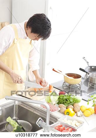 A young man cooking View Large Photo Image Stock Photo - A young man cooking. Fotosearch