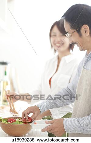 Stock Photo - A young woman making salad. Fotosearch