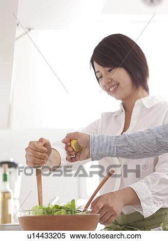 Stock Photography - A young woman making salad. Fotosearch