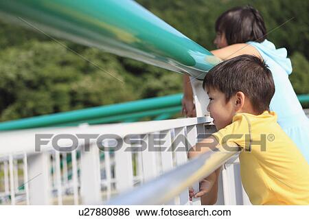 Stock Photograph - Boy and Girl Looking Through Railings. Fotosearch