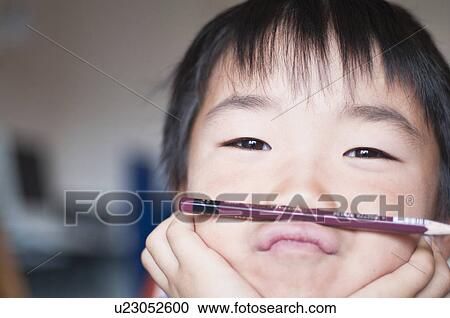 Boy balancing pen between lips and nose, Japan View Large Photo Image Stock Image - Boy balancing pen between lips and nose, Japan. Fotosearch