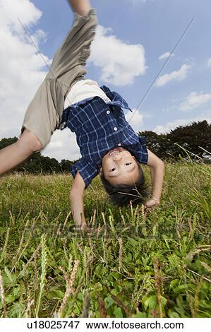 Stock Photo - Boy doing a cartwheel, Japan. Fotosearch