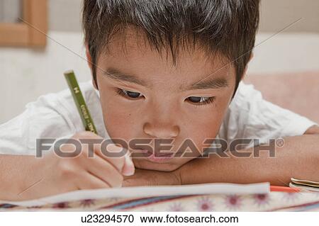 Stock Image - Boy doing homework, Japan. Fotosearch