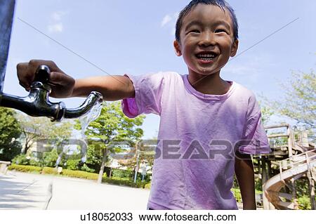 Stock Image - Boy drinking water from faucet, Japan. Fotosearch