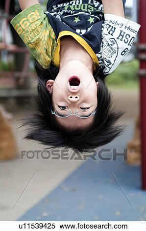 Stock Photography - Boy hanging from monkey bars, Japan. Fotosearch