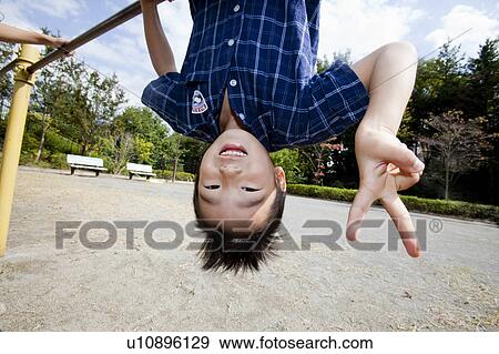 Boy hanging from the gymnastics bar, Japan View Large Photo Image Stock Photo - Boy hanging from the gymnastics bar, Japan. Fotosearch