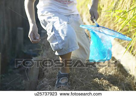 Stock Image - Boy holding butterfly net. Fotosearch