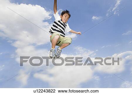Stock Image - Boy jumping in air, Japan. Fotosearch