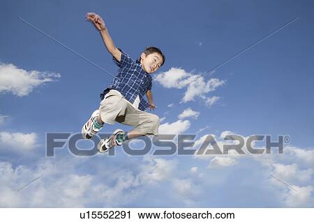 Stock Image - Boy jumping in air, Japan. Fotosearch