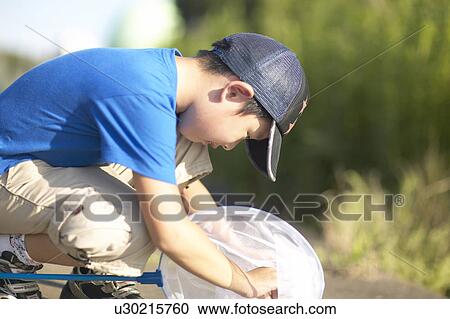 Boy with butterfly net, crouching View Large Photo Image Stock Image - Boy with butterfly net, crouching. Fotosearch