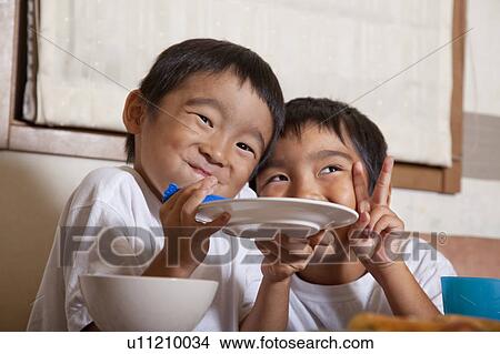 Boys holding a plate together and making a face, Japan View Large Photo Image Picture - Boys holding a plate together and making a face, Japan. Fotosearch