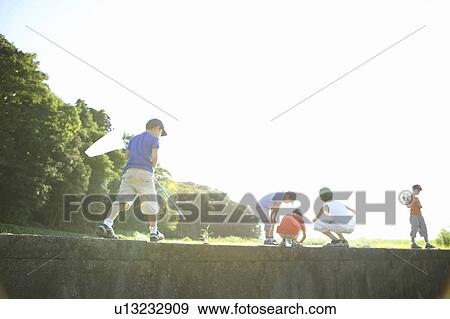 Stock Photo - Boys holding butterfly nets in field, copy space. Fotosearch