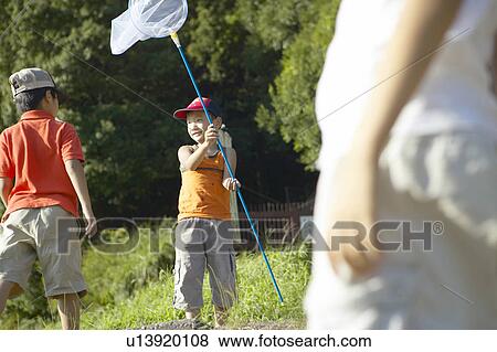 Stock Photo - Boys holding butterfly nets in field. Fotosearch