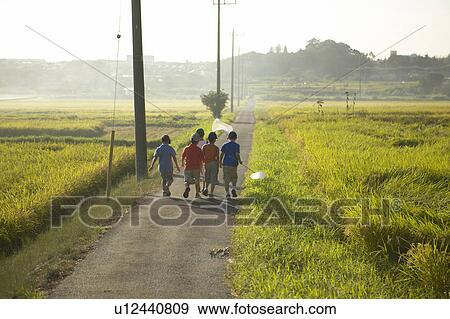 Stock Photo - Boys holding butterfly nets walking in field. Fotosearch