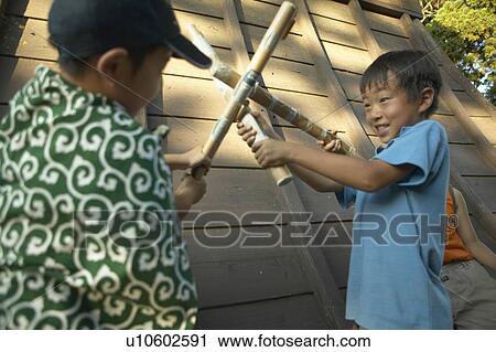Stock Image - Boys playing beside old building. Fotosearch