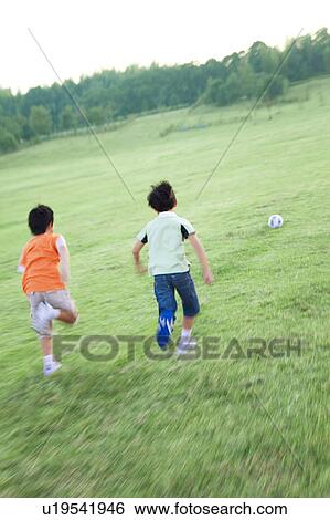 Boys playing soccer in field, blurred motion View Large Photo Image Stock Photograph - Boys playing soccer in field, blurred motion. Fotosearch