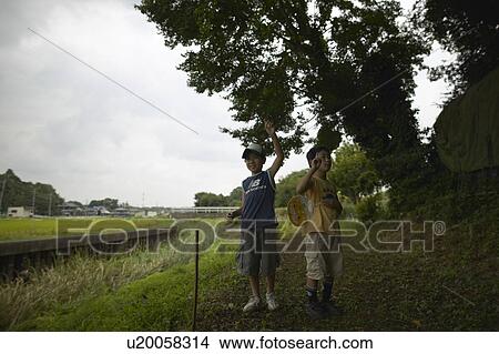 Picture - Boys standing under tree. Fotosearch