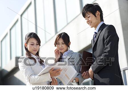 Stock Photo - Business people looking at documents. Fotosearch