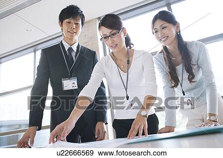 Business people looking at documents View Large Photo Image Stock Photo - Business people looking at documents. Fotosearch
