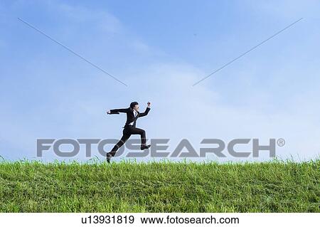 Stock Photo - Businessman Jumping in Field. Fotosearch