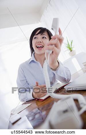 Stock Image - Businessman Taking a Call for a Colleague. Fotosearch