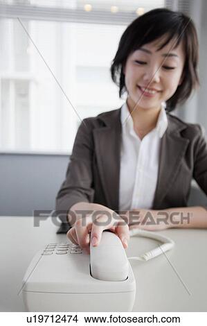 Picture - Businesswoman Reaching for Telephone. Fotosearch