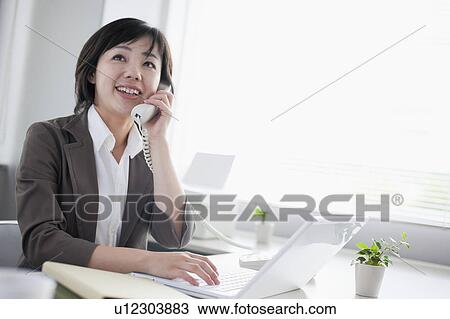Businesswoman Talking on the Phone and Using Laptop View Large Photo Image Stock Image - Businesswoman Talking on the Phone and Using Laptop. Fotosearch