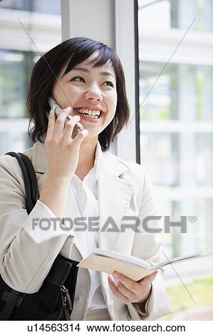 Picture - Businesswoman With Personal Organizer Talking on the Phone. Fotosearch