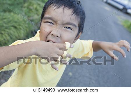 Stock Image - Close-up of a boy making a face, Japan. Fotosearch