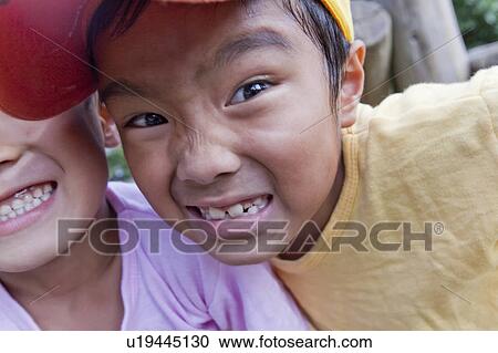Stock Image - Close-up of boys making faces, Japan. Fotosearch