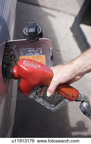 Close-up of man pumping gas into car View Large Photo Image Stock Photo - Close-up of man pumping gas into car. Fotosearch