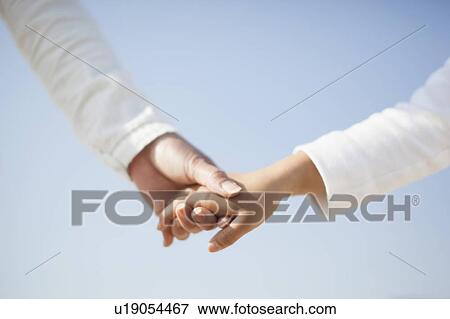 Stock Photo - Close up of Mother and Daughter Holding Hands. Fotosearch