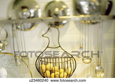 Stock Image - Eggs in a wire basket hanging from kitchen. Fotosearch
