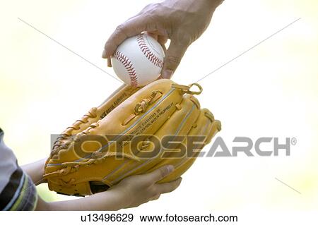 Stock Photo - Father handing over baseball to son. Fotosearch